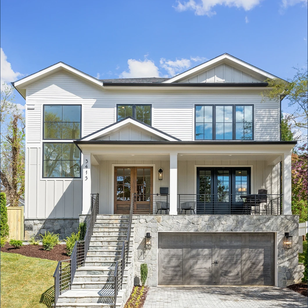 Contemporary two-story luxury home with expansive windows, covered porch, stone base and stairs, and a wood-paneled two-car garage.